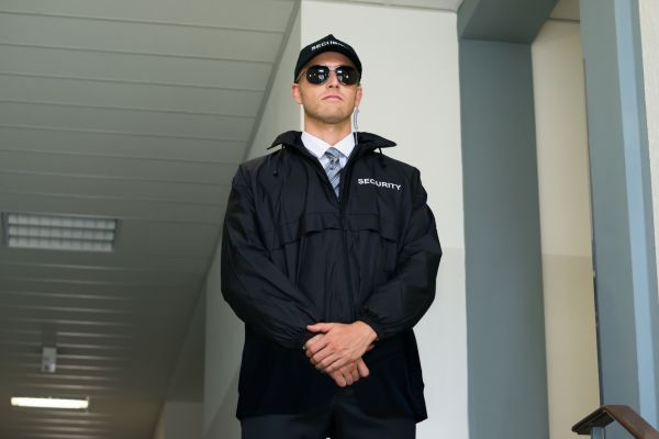 Armed security guard guarding the building entrance.