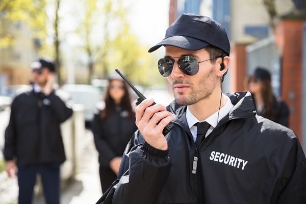Security Guard on duty holding communication radio